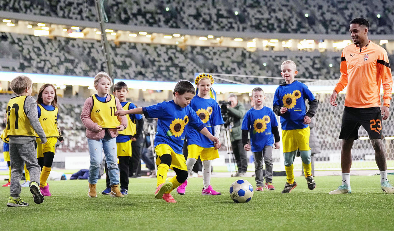 ウクライナ復興支援の慈善試合前、選手らによるサッカー教室に参加した同国の子どもたち（共同）