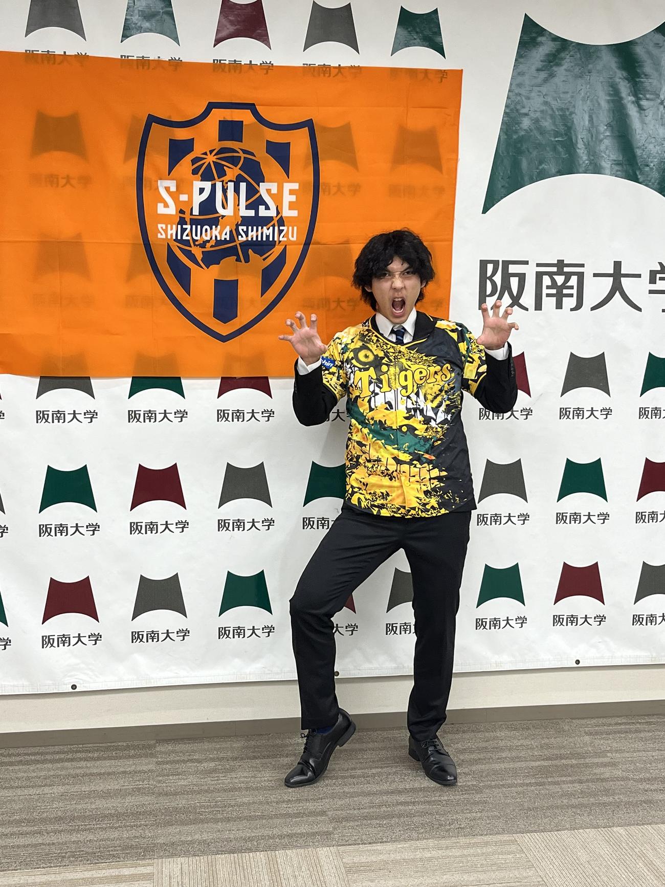阪神日本一を喜び、仕込んでいたユニフォームで記念撮影する阪南大DF高木践（撮影・永田淳）