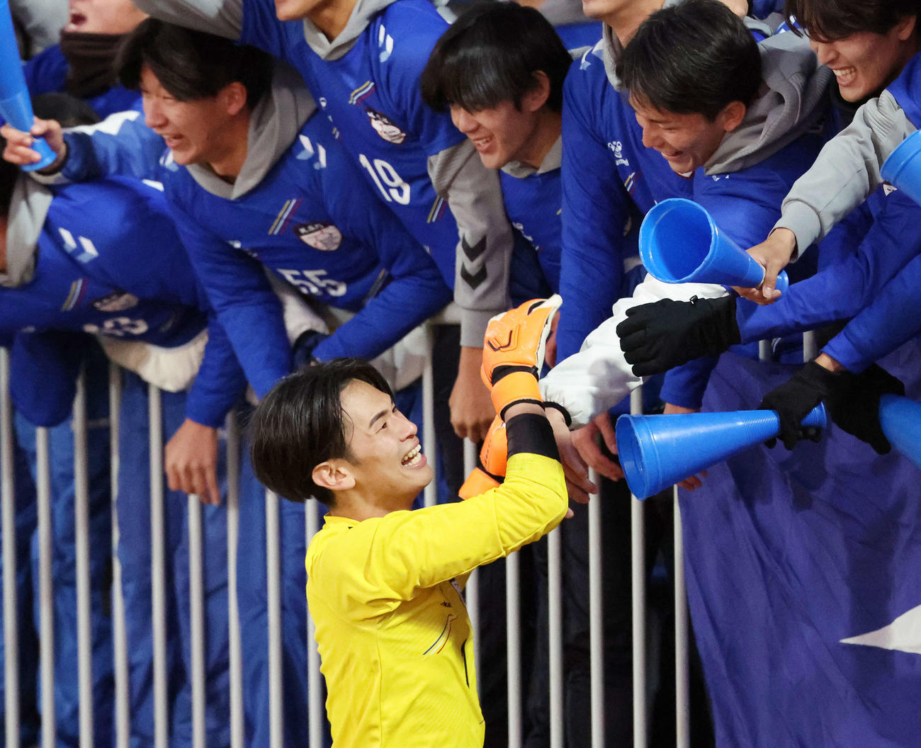 流通経大対京産大　PK戦で勝利し、応援スタンドのチームメートとタッチを交わす京産大・GK山本（下）（撮影・宮地輝）