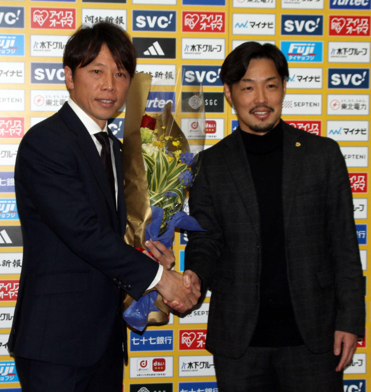 富田クラブコミュニケーター（右）から花束を受け取り、握手をかわす梁（撮影・木村有優）