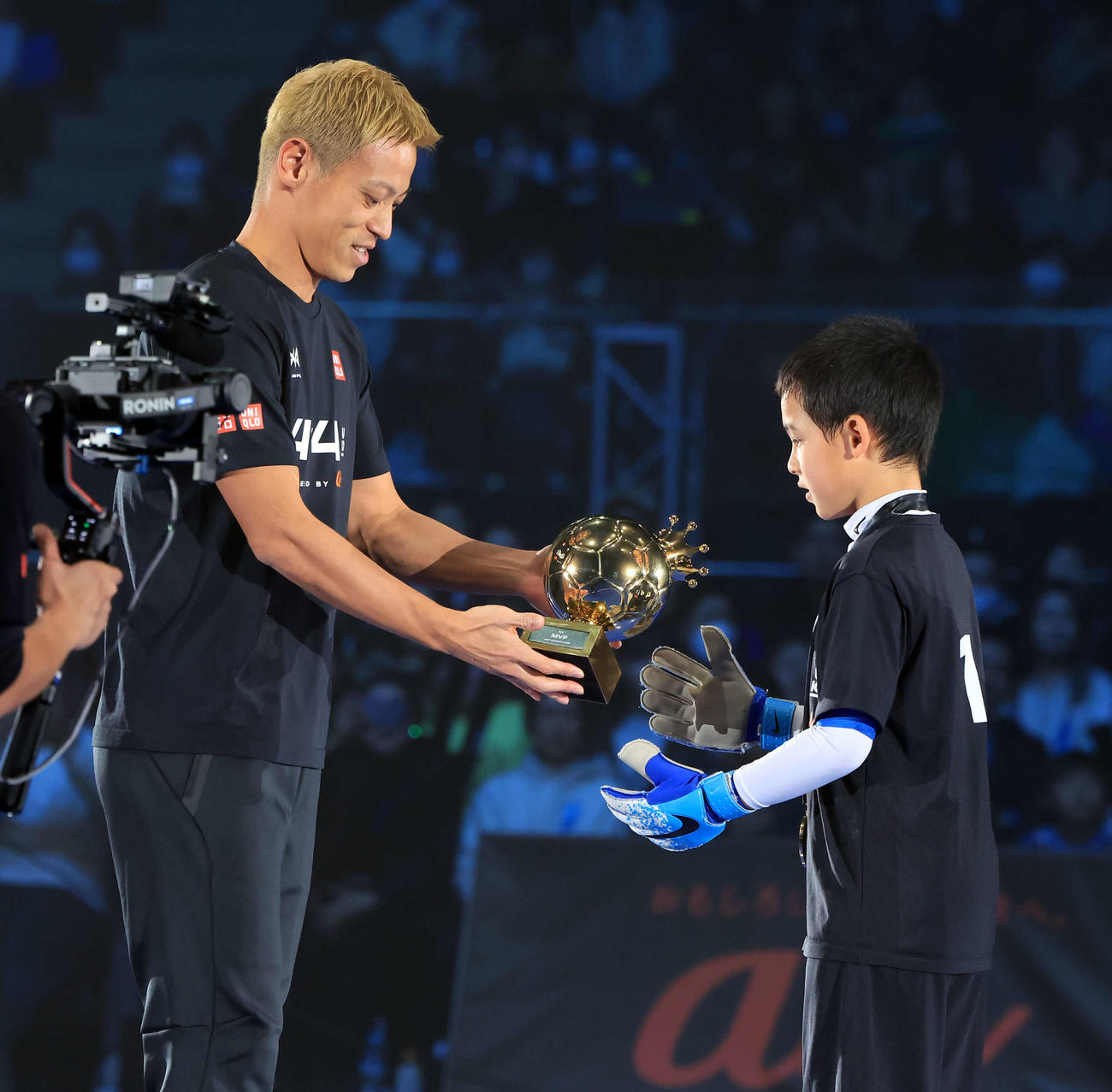 「4v4JAPANCUP U10 2023」でMVPに輝いた選手にトロフィーを渡す本田圭佑（左）（撮影・浅見桂子）