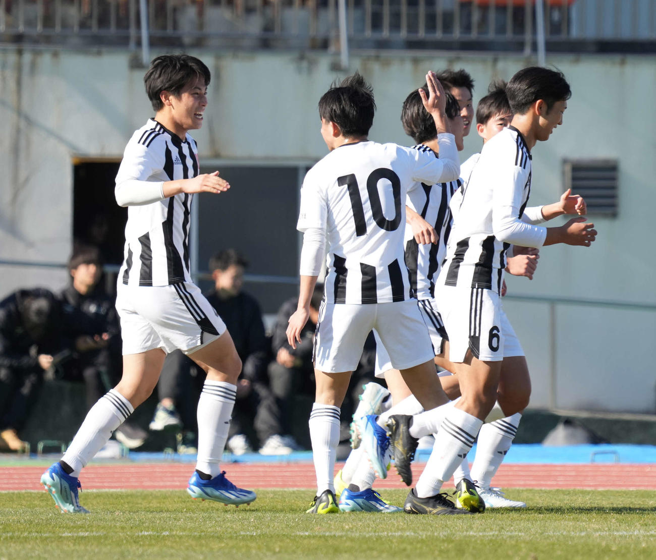 名古屋対日章学園　前半、名古屋・足立（左）は同点ゴールを奪いイレブンの祝福を受ける（撮影・小沢裕）