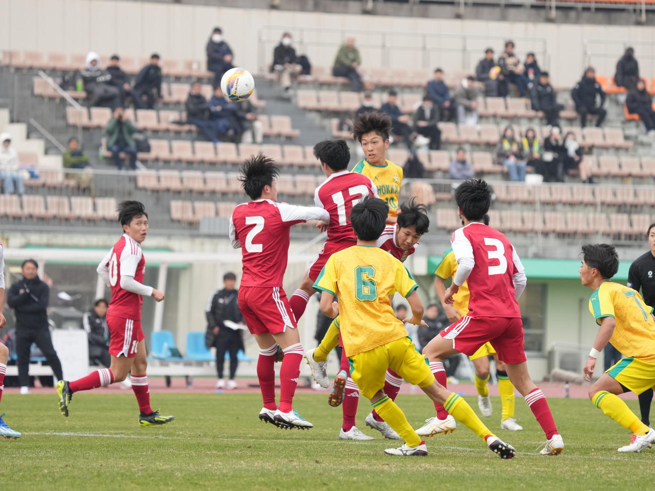 全国高校サッカー選手権大会2回戦　北海対名古屋　前半、ゴール前の浮き球を競り合う北海・田中（中央）＝＝2023年12月6日（撮影・小沢裕）