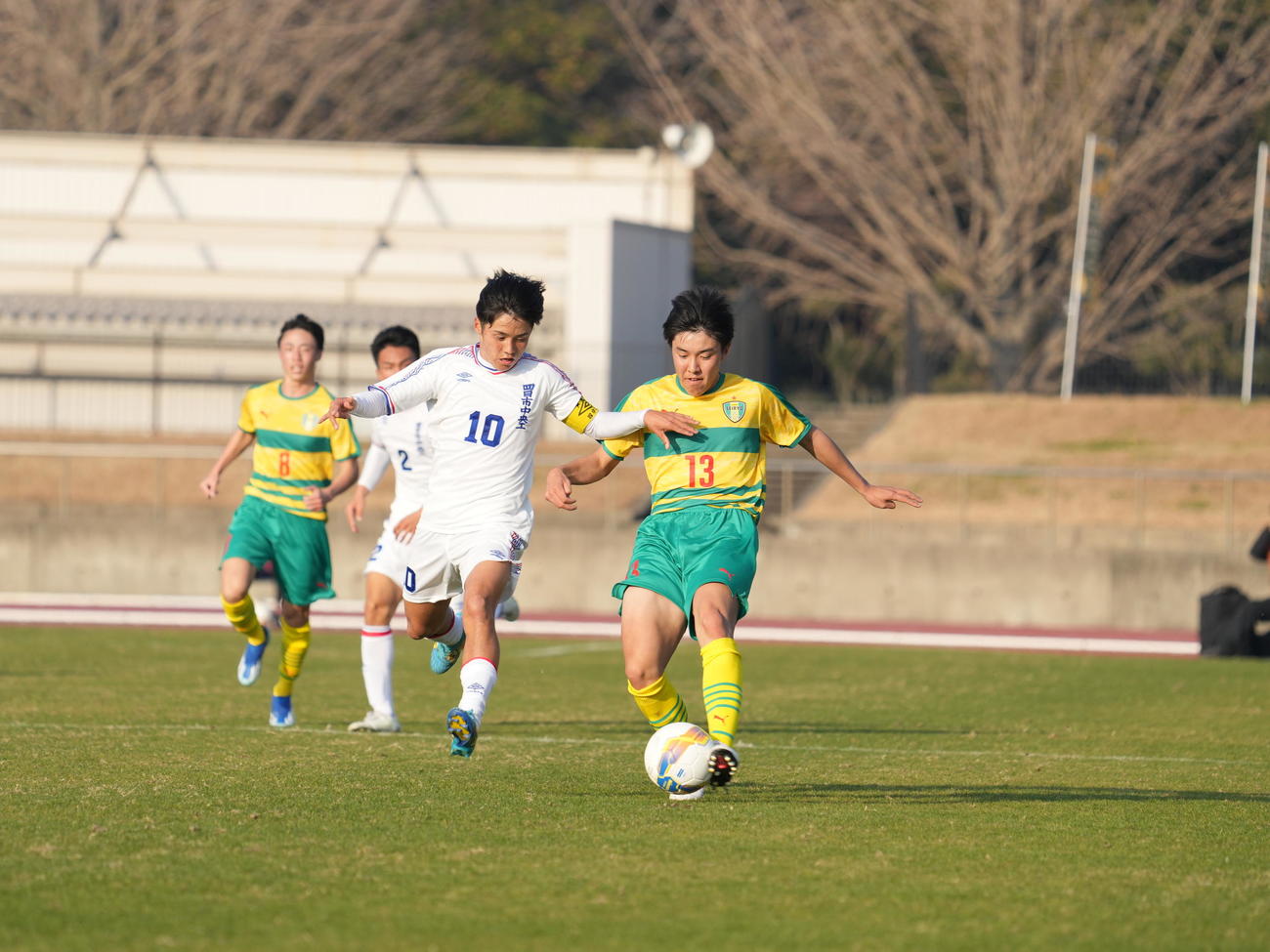全国高校サッカー選手権大会2回戦　星稜対四日市中央工　前半、ボールを競り合う星稜・中村（右）と四日市中央工・片岡＝2023年12月31日