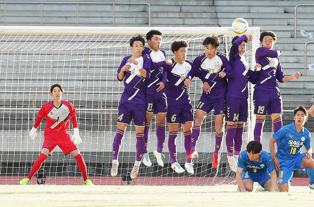 堀越対佐賀東　後半、相手FKに必死の守備を見せるGK吉富（左端）ら（撮影・足立雅史）