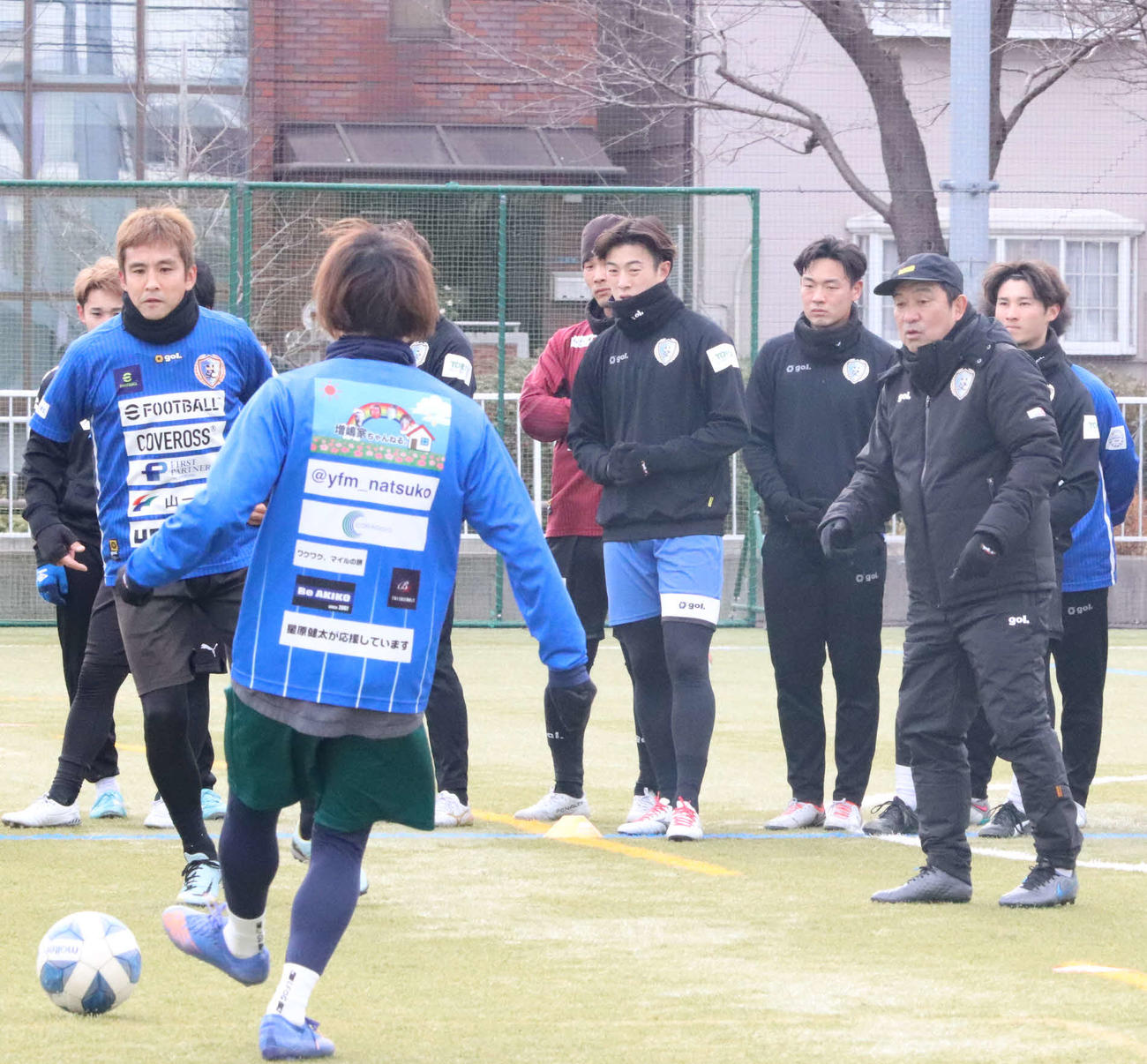 風間監督（右）の下で始動した南葛SC。コーチ兼選手のMF稲本（左）がメニューの手本を見せる
