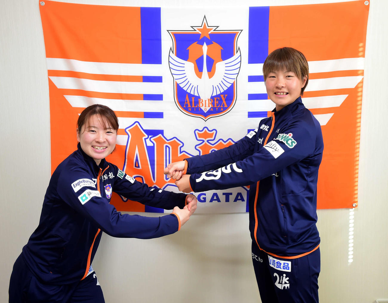 新年にちなんで餅つきポーズをする新潟レディースの年女、武田（左）と白井