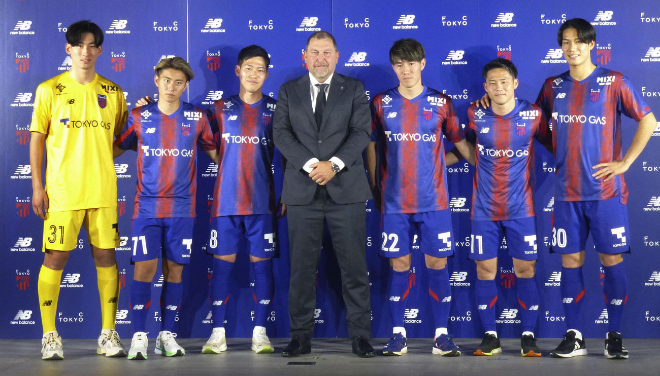 東京の新体制発表会見でポーズをとるクラモフスキー監督（中央）と選手たち（共同）