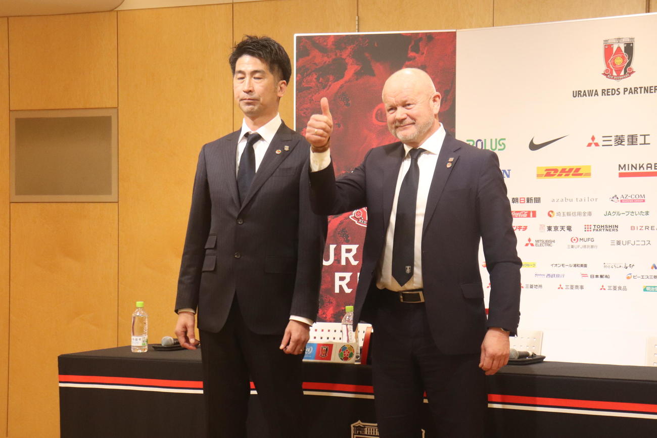 サムアップポーズをする浦和のヘグモ監督（右）。左は西野TD