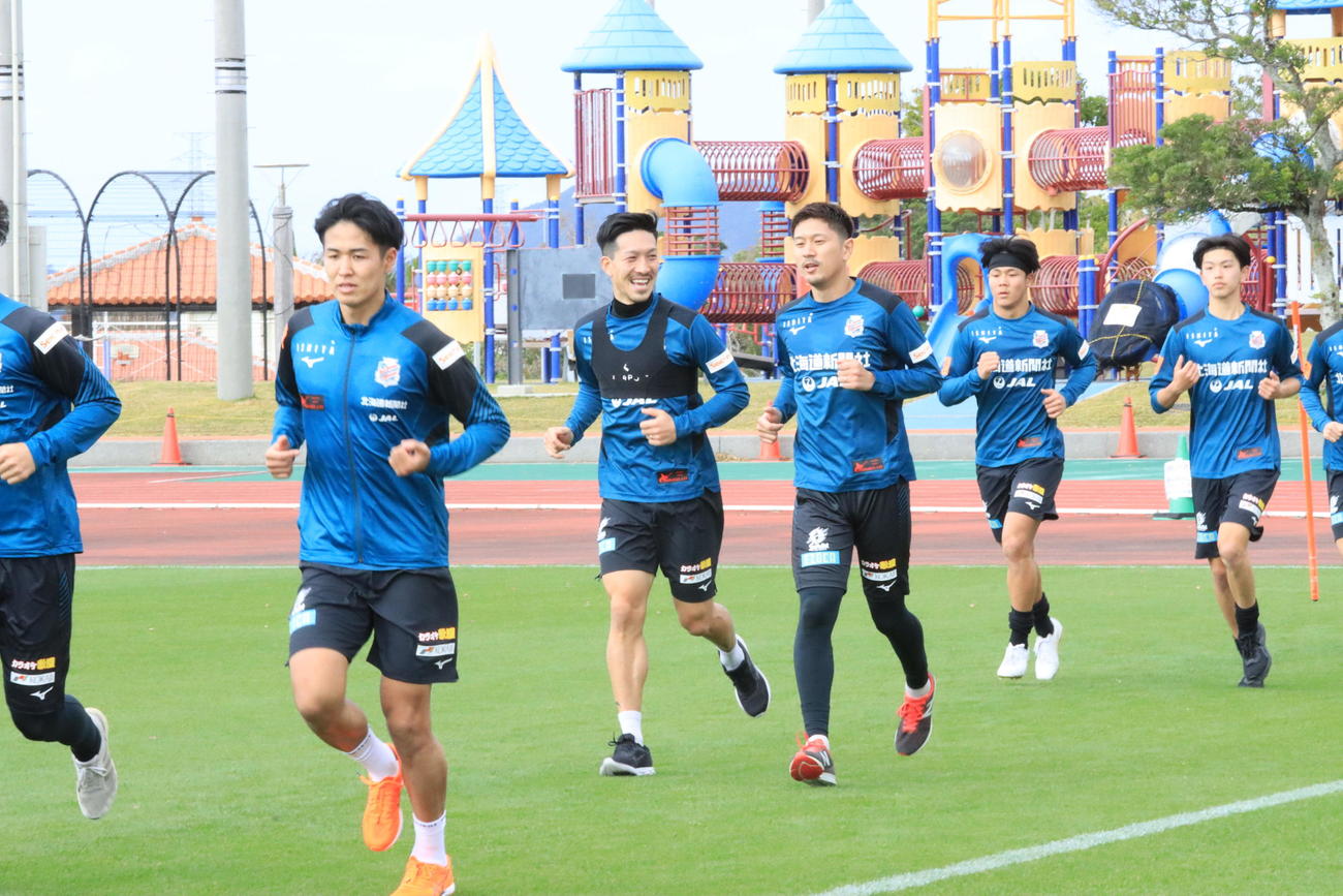 沖縄キャンプ初日の午前練習でランニングする札幌の選手たち（撮影・保坂果那）