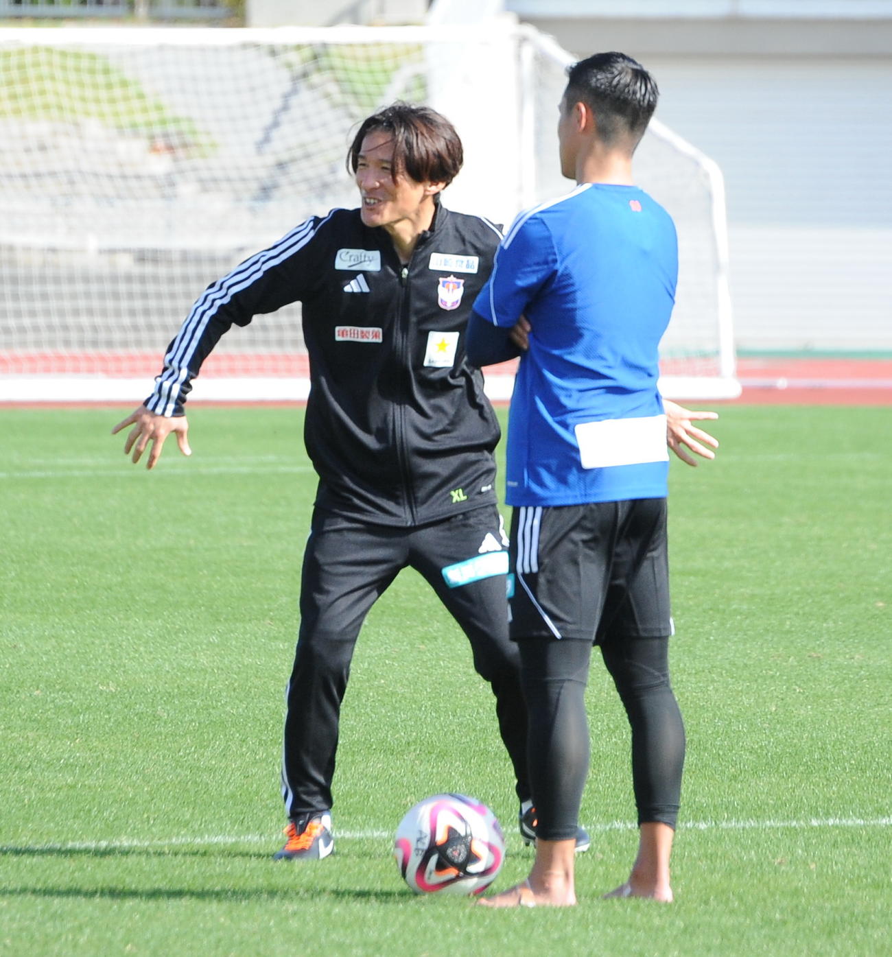 沖縄キャンプ5日目の午前練習後、田中コーチ（左）とプレーについて話し込む小野