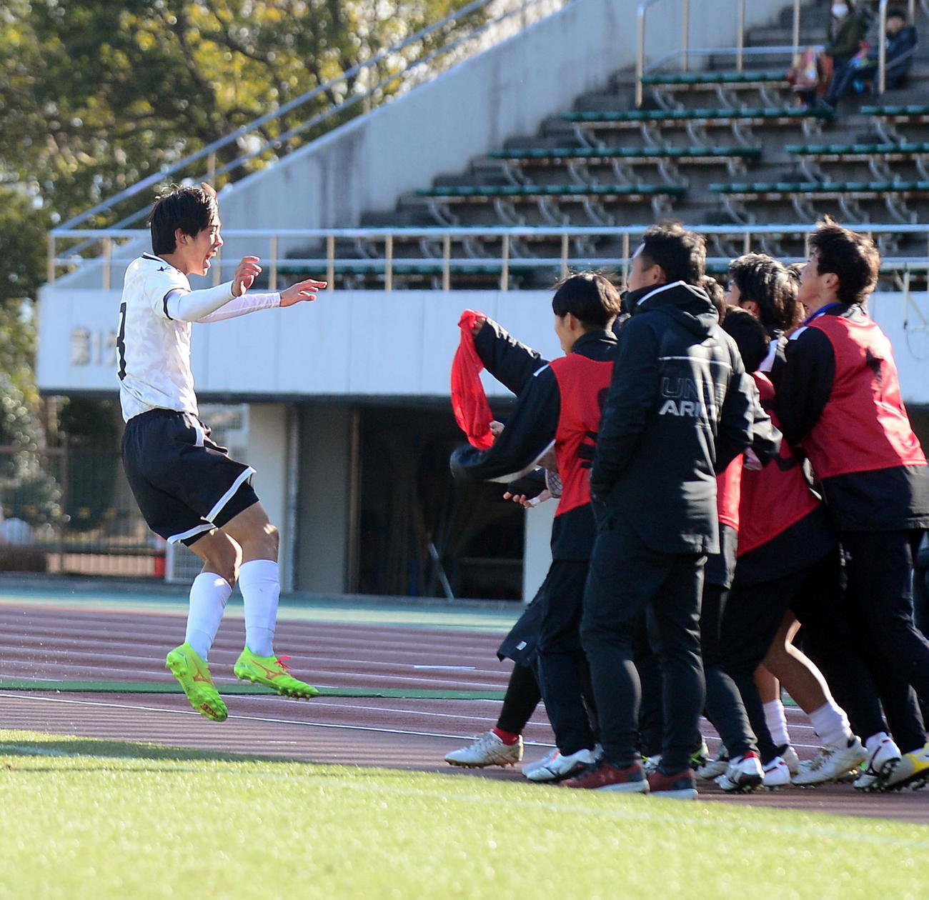 決勝点を決め、ベンチメンバーに飛び込む浜名DF小島（左）
