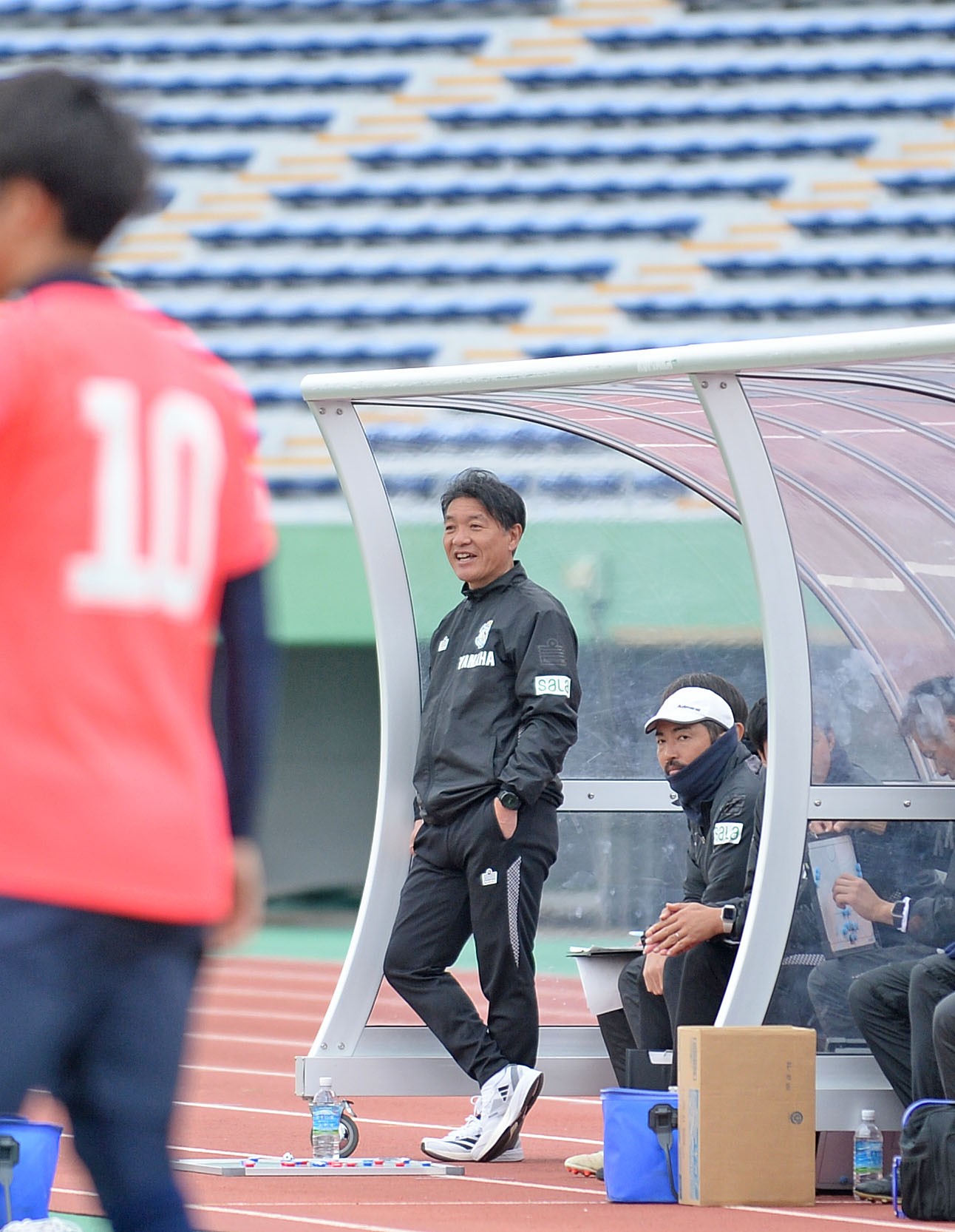 ベンチから戦況を見つめる磐田の横内監督（中央）