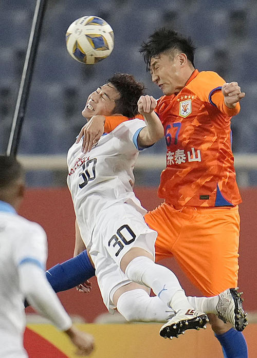 山東対川崎F　前半、空中で競り合う川崎・瀬川（左）（共同）