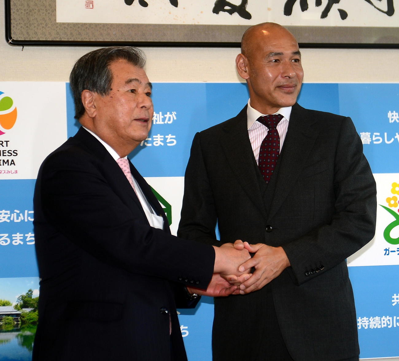 豊岡市長（左）と記念撮影に納まる高原氏