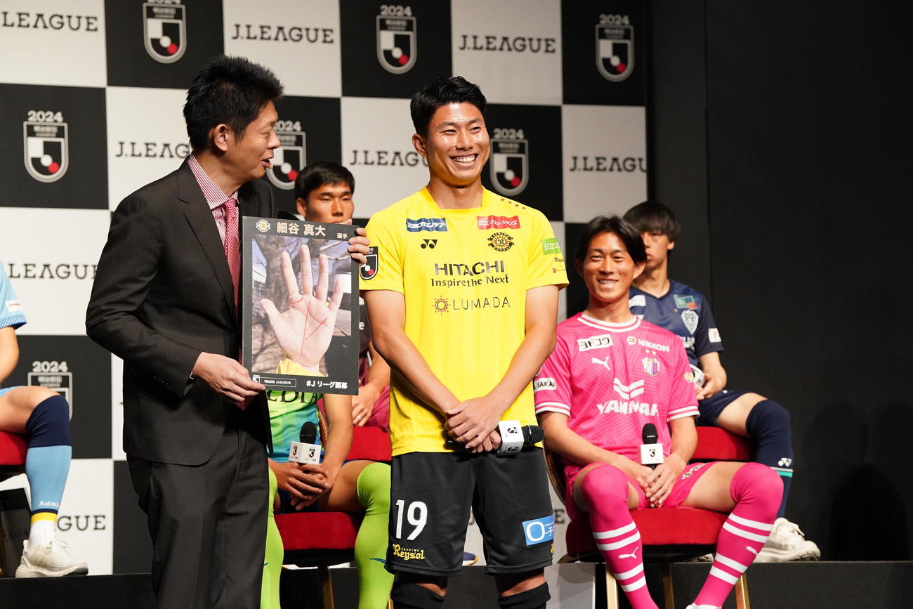 2024Jリーグ開幕PRイベントで手相占いの島田秀平氏（左）から今季の活躍を告げられ笑顔を見せる柏細谷。右はC大阪毎熊（撮影・小沢裕）