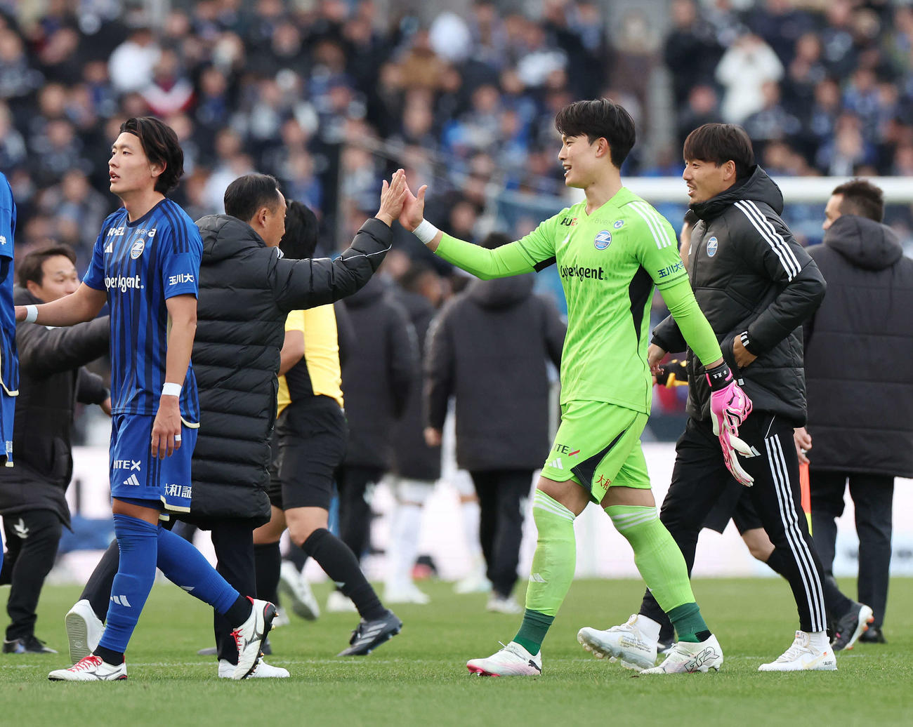 町田対G大阪　試合後、タッチを交わす町田黒田監督（中央左）とGK谷（同右）（撮影・宮地輝）