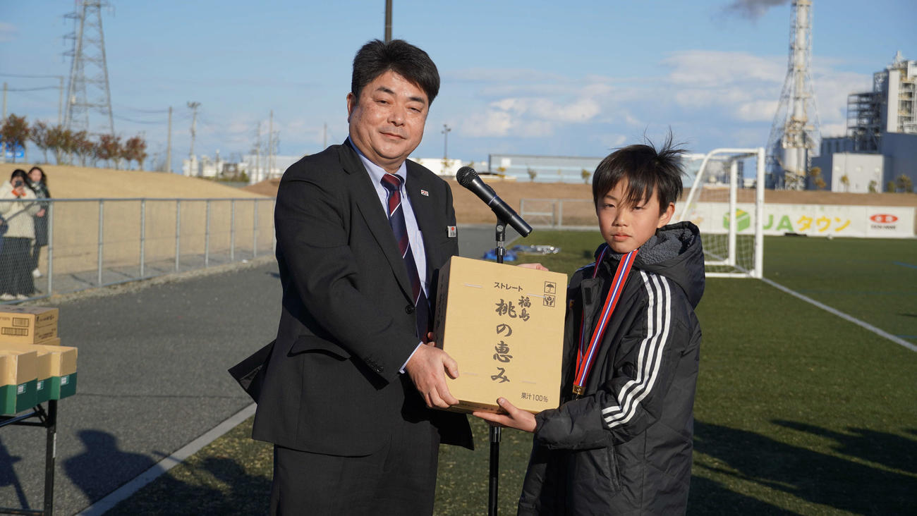 優勝チームに副賞を手渡す、JA全農福島の太田豊副本部長（左）