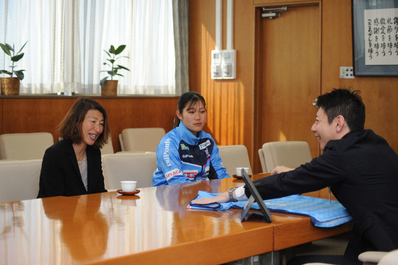 草地磐田市長（右）にユニホームを贈呈し、談笑する静岡SSUボニータの本田監督（左）と安間