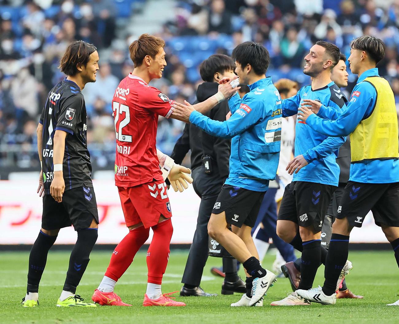 G大阪対磐田　磐田に勝利したG大阪宇佐美（左）とGK一森（左から2人目）はイレブンと笑顔を見せる（撮影・上田博志）