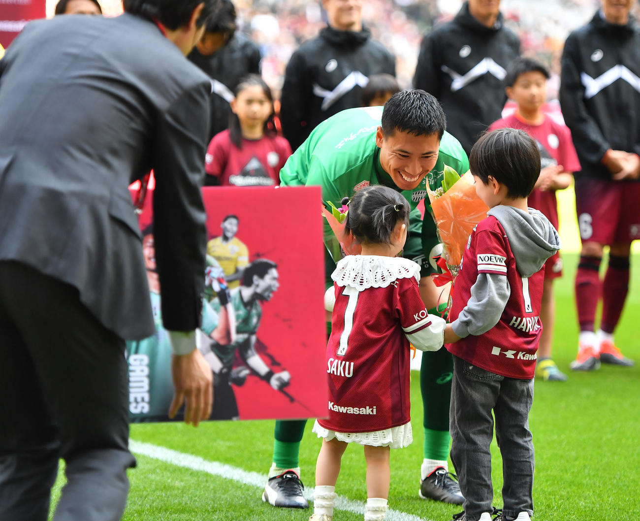 神戸対広島　J1通算100試合出場を達成し表彰を受けた神戸GK前川は自身の子どもから花束を受け取る（撮影・清水貴仁）