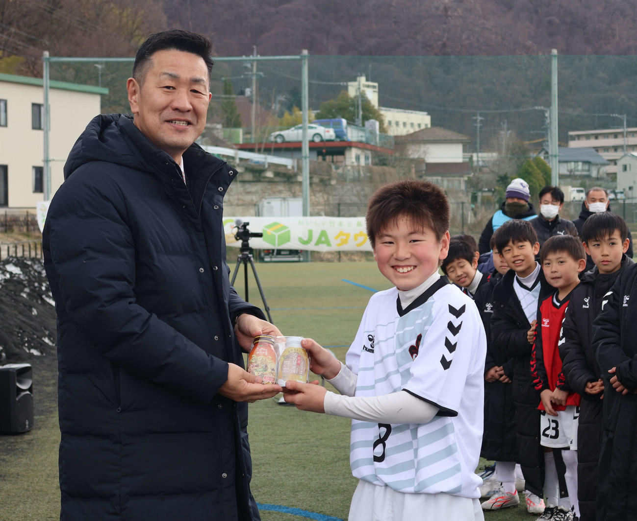 優勝チームに副賞を手渡すJA全農広報・調査部の山口文経次長（左）
