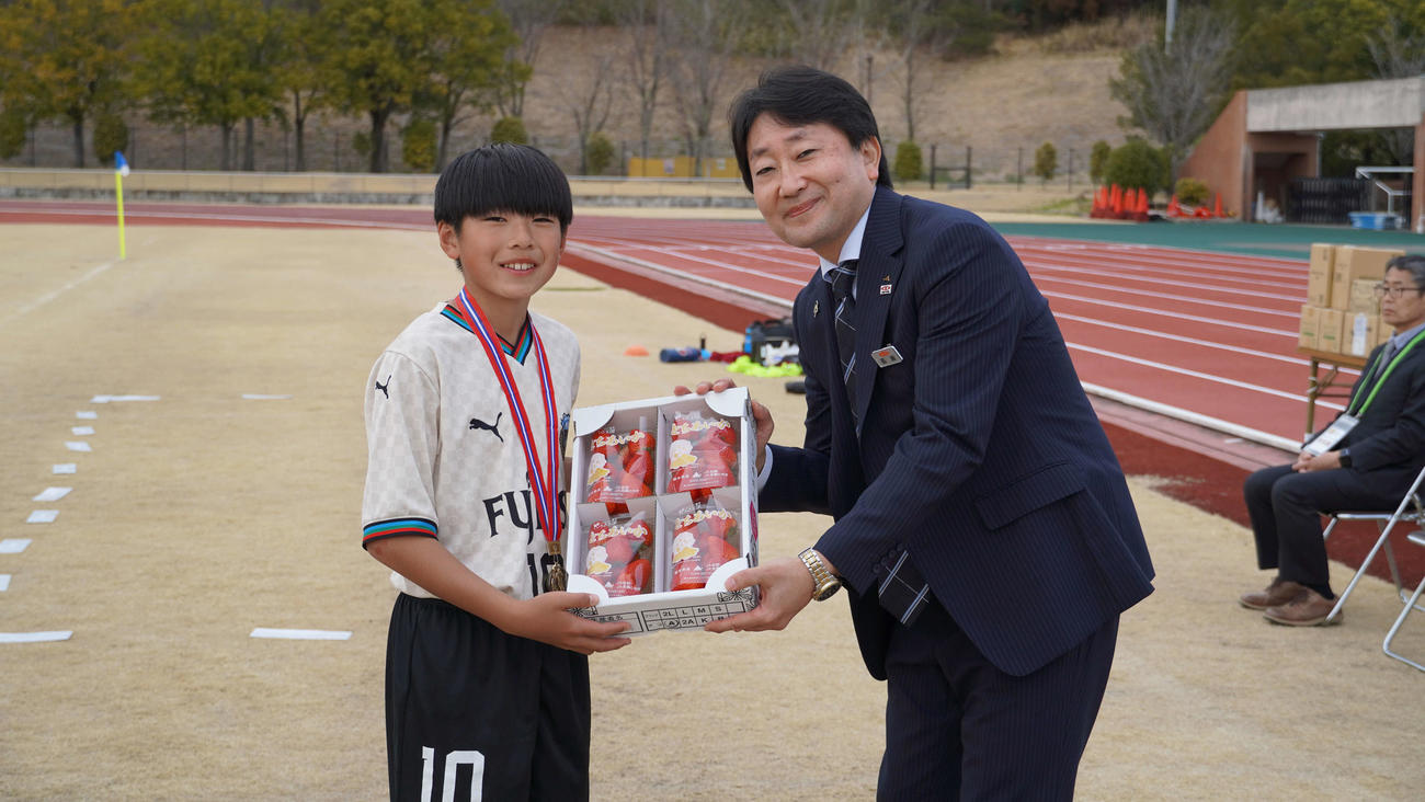 優勝チームに副賞を手渡すJA全農とちぎ管理部・高瀬和幸部長（右）