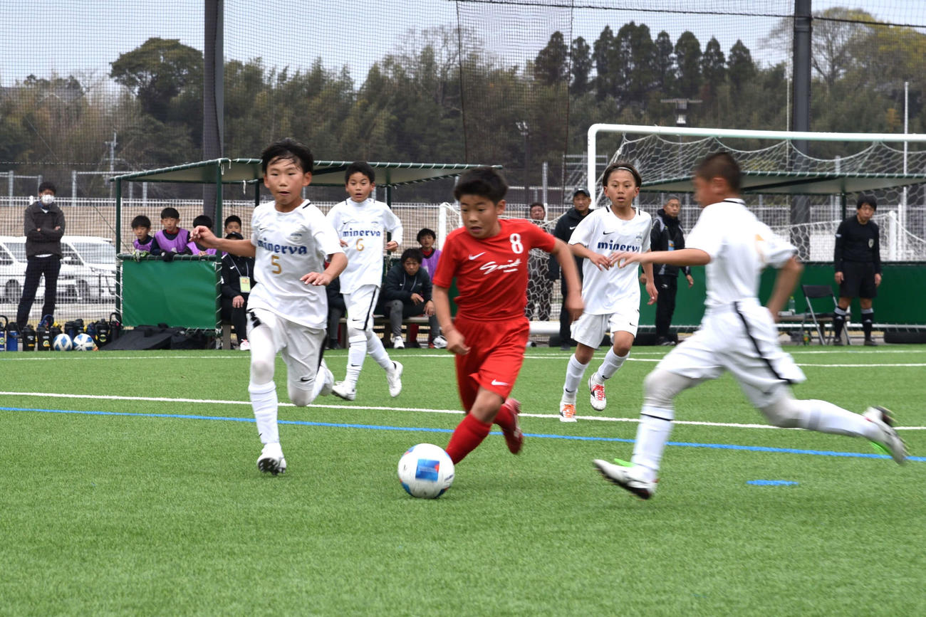別府フットボールクラブ．ミネルバU－12戦でドリブルを仕掛けるSon’s甲佐の宮地結樹（写真中央）