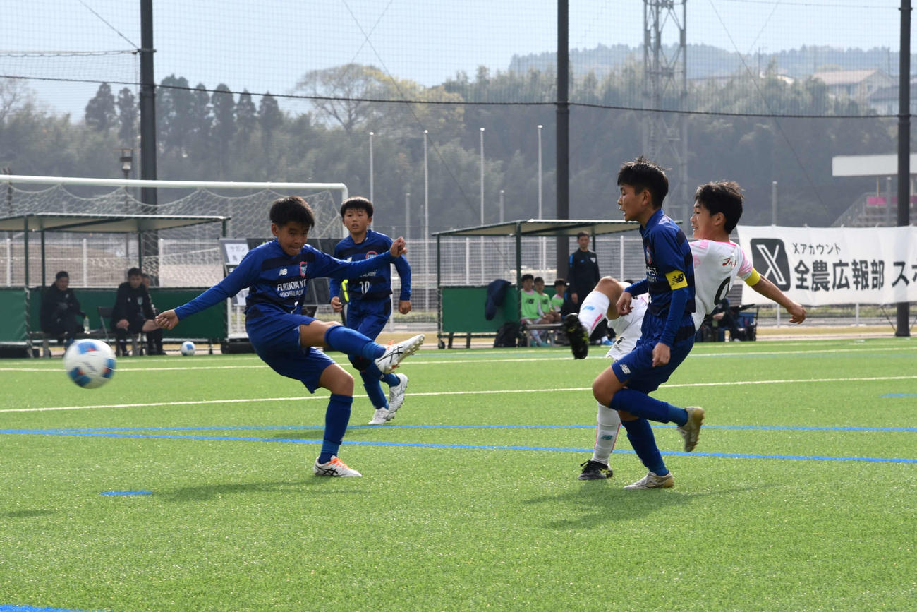 準々決勝の福岡西フットボールアカデミー戦で、体勢を崩しながらもシュートを放ち、2点目のゴールを決めるサガン鳥栖U－12の児玉啓明（写真右から2人目）