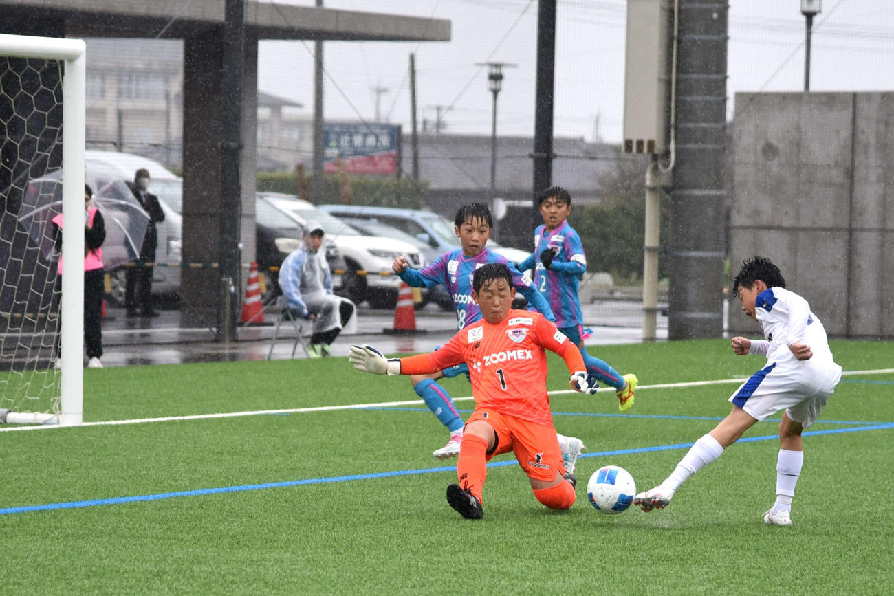 準決勝の大分トリニータU－12戦で、相手の決定機に飛び出してシュートをブロックする、サガン鳥栖GK永田拓夢（写真中央）
