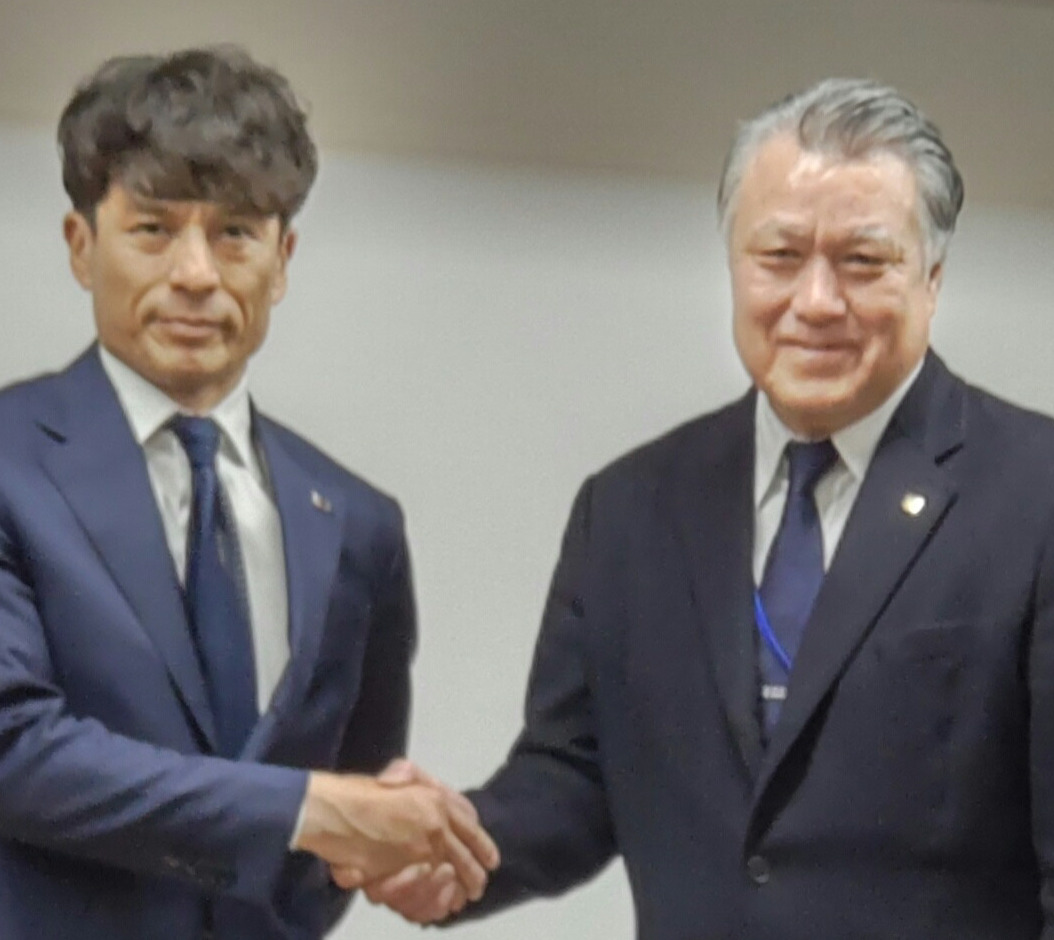 田嶋前会長（左）と握手をする新会長の宮本氏