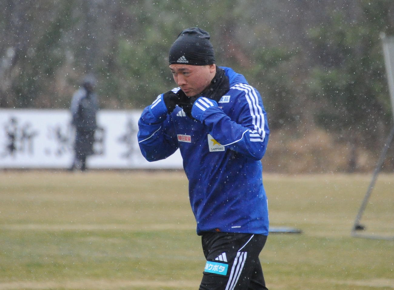 26日、雪がちらつく中、ランニングする小見