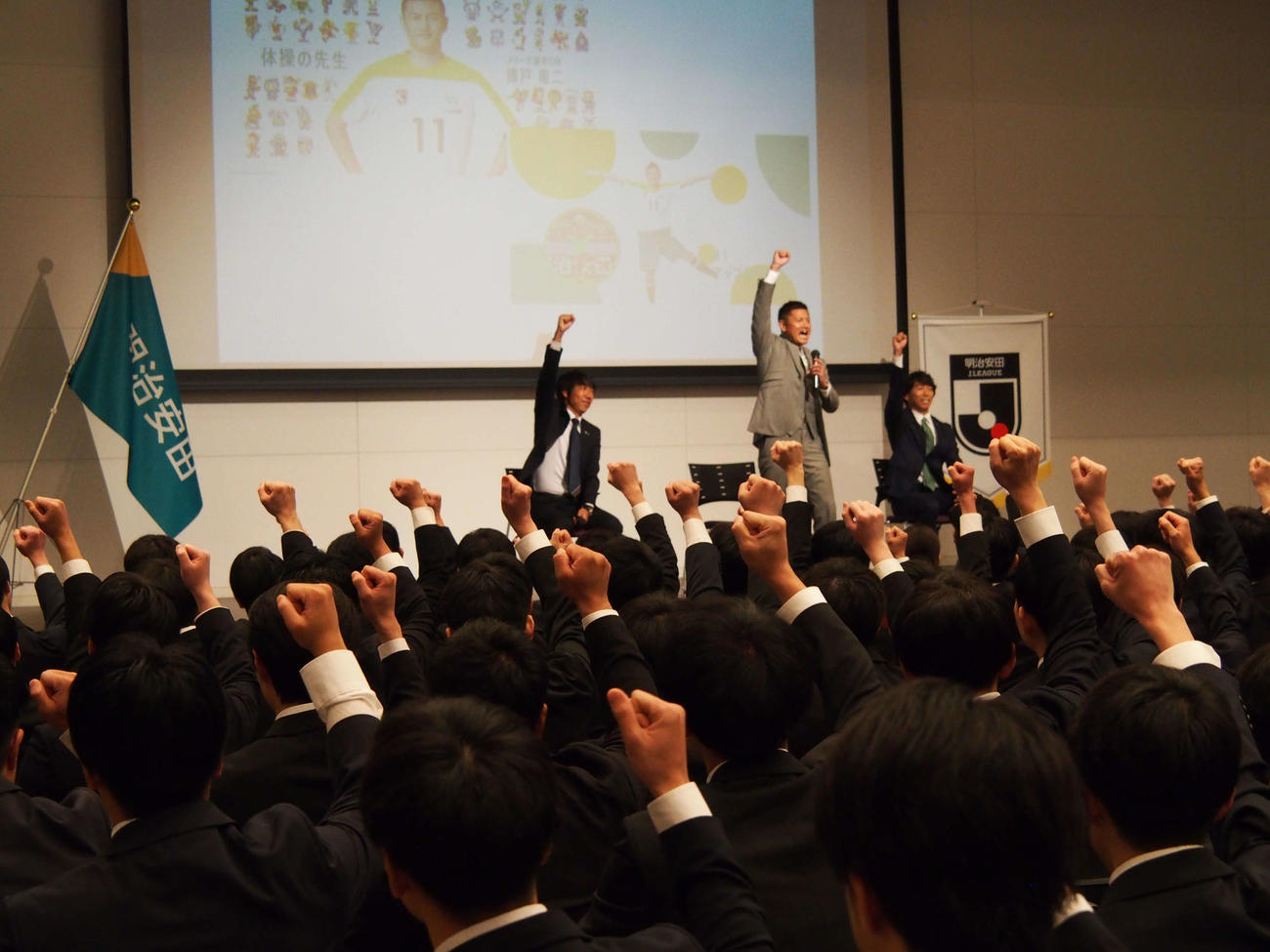 明治安田の新入社員と「おばんざい」の掛け声で盛り上がる播戸竜二氏（中央）＝2024年4月1日