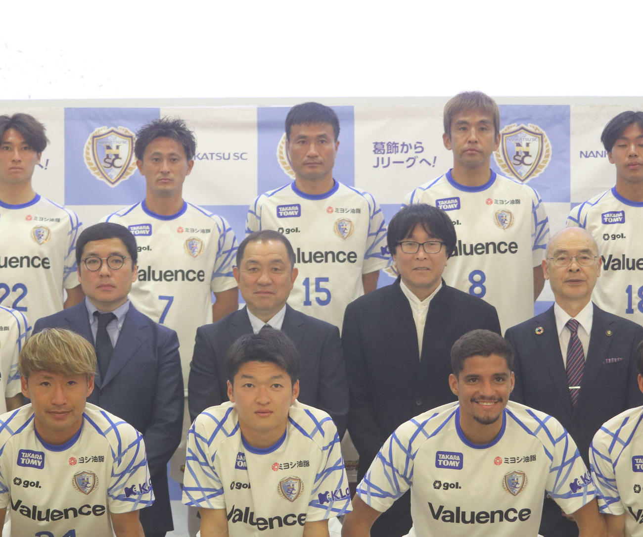 南葛SCの風間八宏監督（中列左から2番目）、高橋陽一代表取締役（中列右から2番目）、岩本義弘GM（中列左）。（後列右から）MF稲本、今野、関口