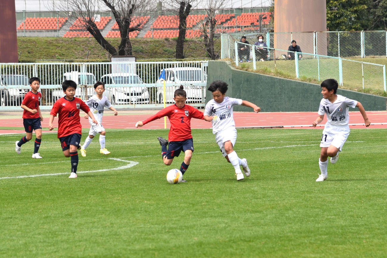 ファジアーノ岡山U－12戦で、相手と競り合いながらボールを前線に運ぶ鳥取KFC U－12の金丸旺生（右から3人目）