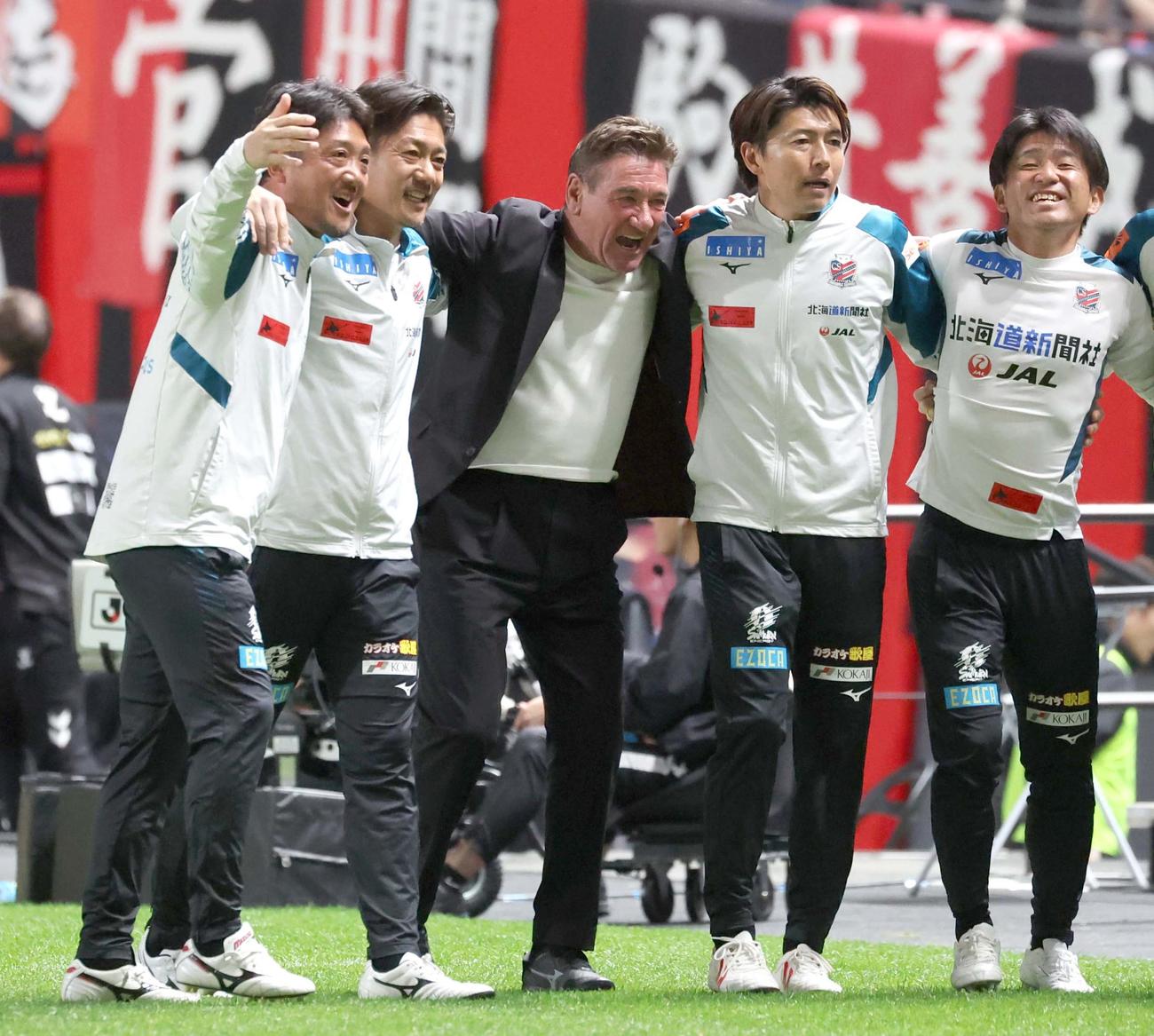 札幌対G大阪　今季初勝利しスタッフと肩を組んで喜ぶ札幌ペトロビッチ監督（中央）（撮影・黒川智章）