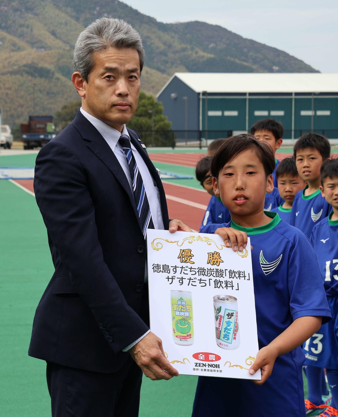 優勝チームに副賞を手渡すJA全農とくしま・坂本雅彦本部長（左）