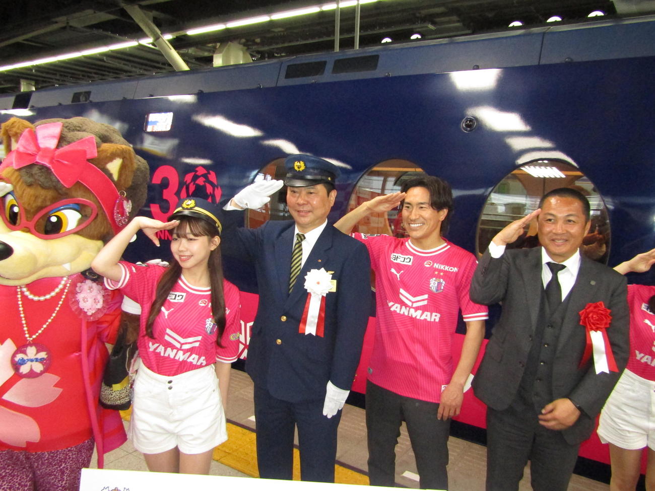 南海電鉄の特急ラピートの前で記念撮影に応じるC大阪登里（右から2人目）と森島社長（右端）
