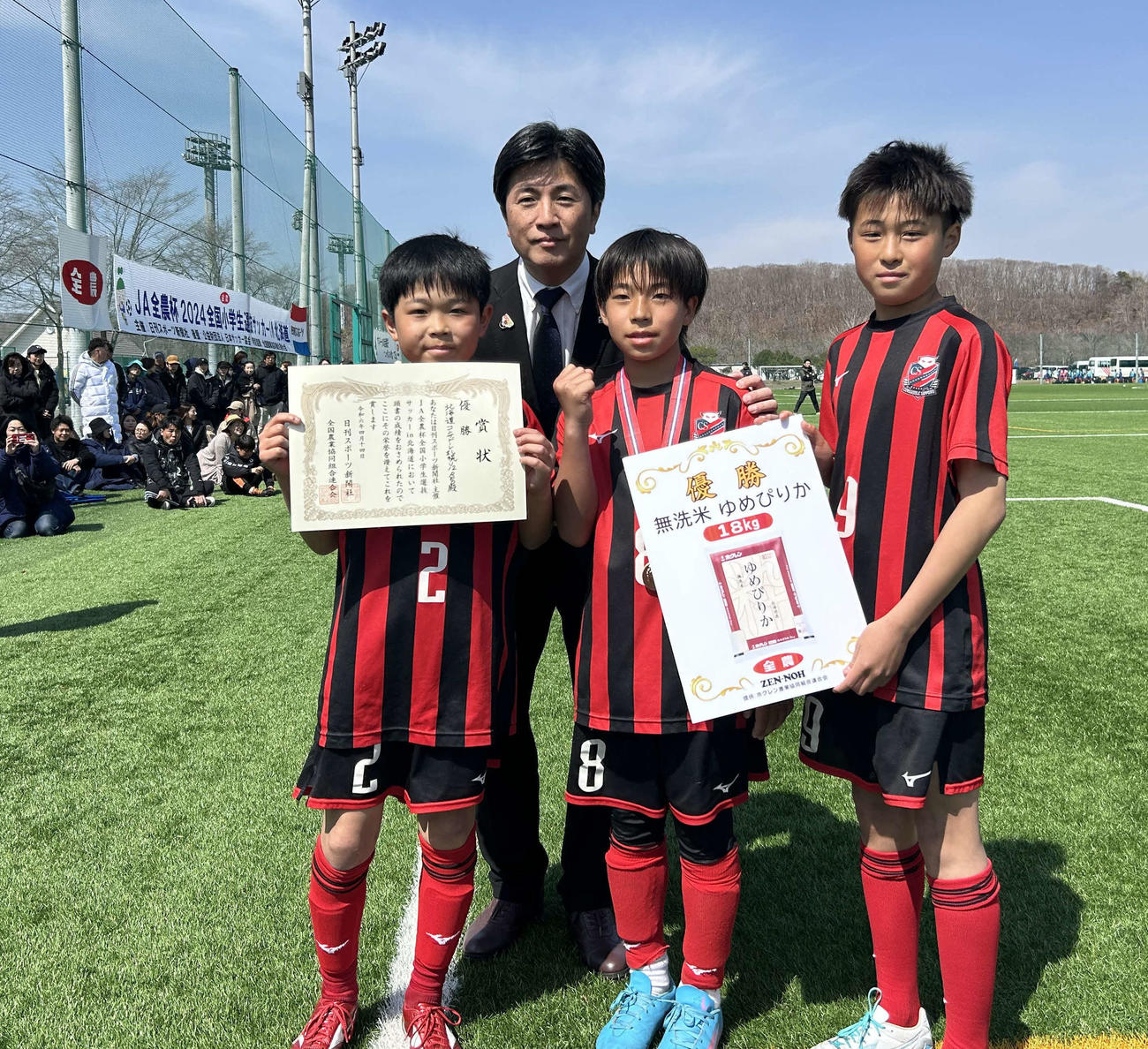 優勝チームに副賞の「ゆめぴりか」を手渡したJA全農の澤田部長（左から2番目）
