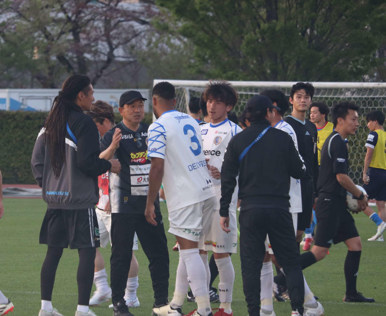 今季初勝利を挙げ、南葛SCの風間八宏監督（左から2人目）は選手をねぎらう