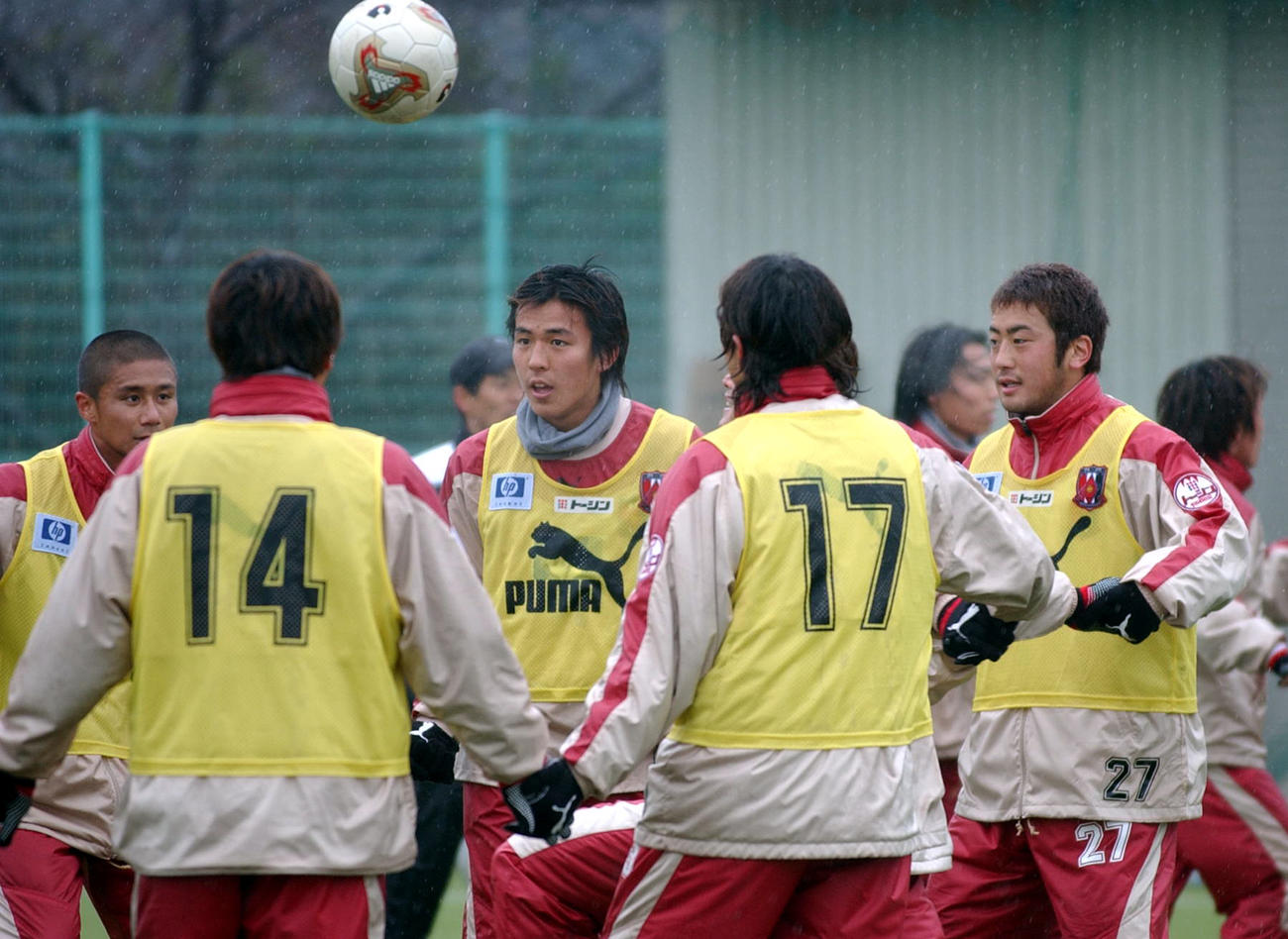 チームメートと手をつないだ状況でボール回しを行う左から坪井慶介、長谷部誠、小林宏之（2003年3月撮影）