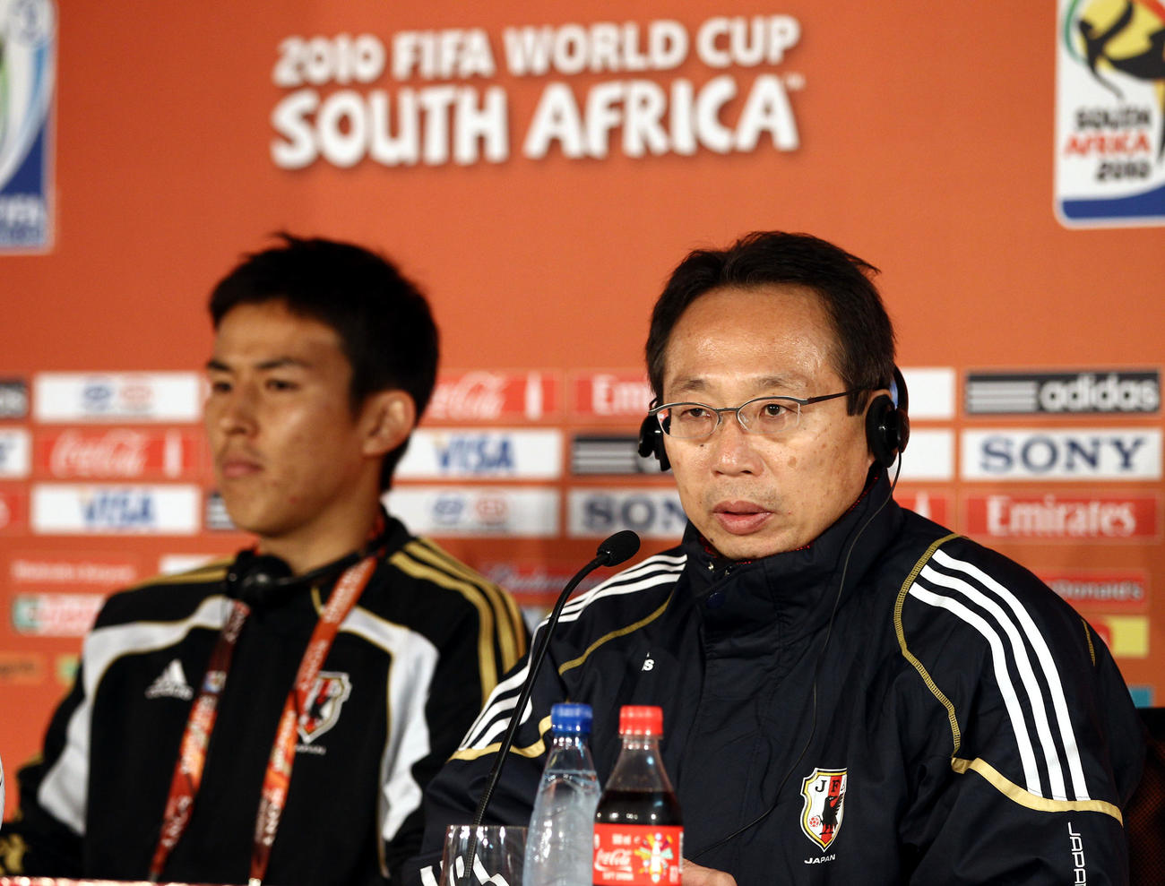 W杯南アフリカ大会　日本代表練習　会見で険しい表情を見せる岡田武史監督（右）と長谷部誠（2010年6月28日撮影）