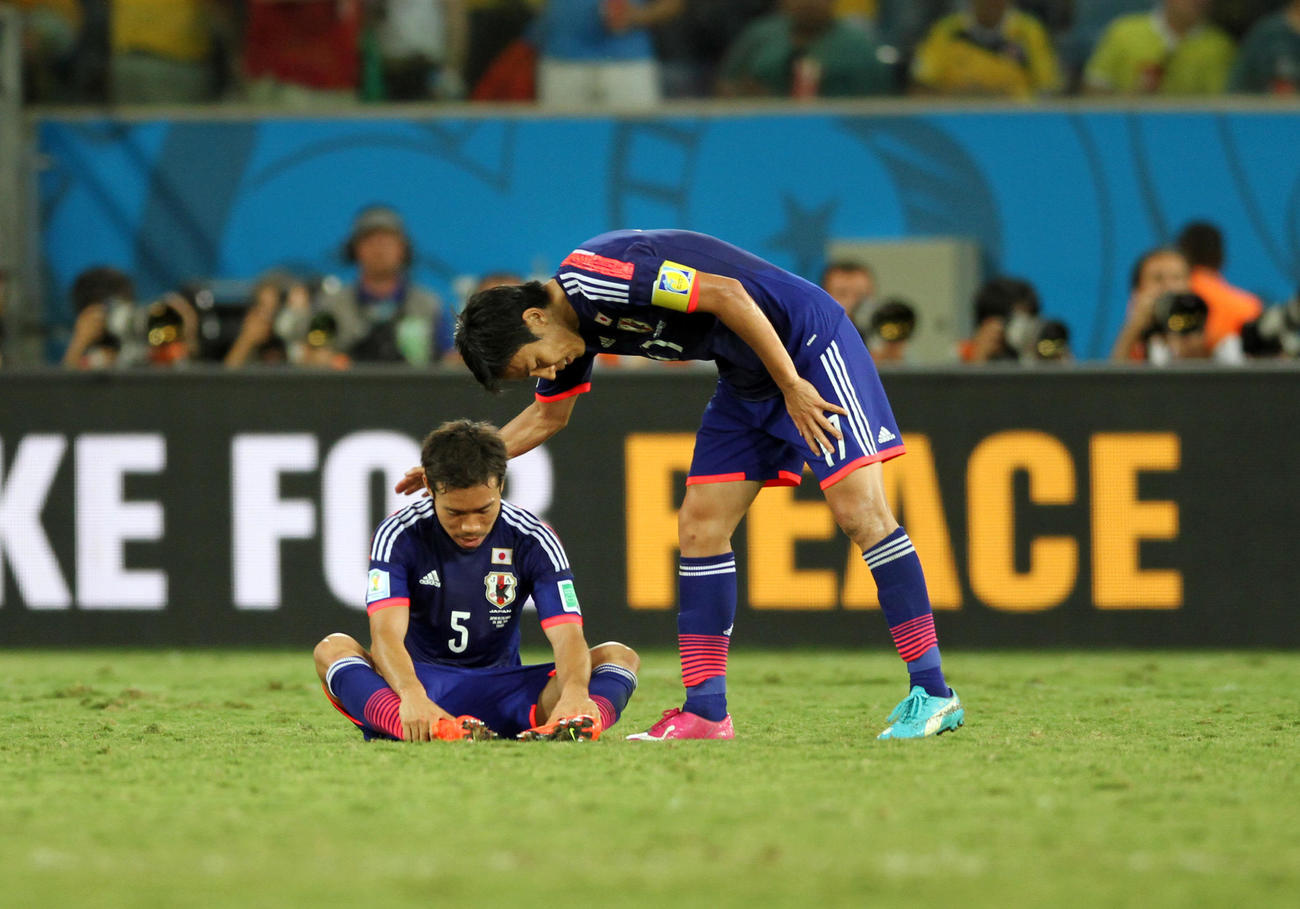 サッカーW杯ブラジル大会　第13日　1次リーグC組　日本対コロンビア　1次リーグ敗退が決まり、長友佑都（左）は長谷部誠から声を掛けられる（2014年6月24日撮影）