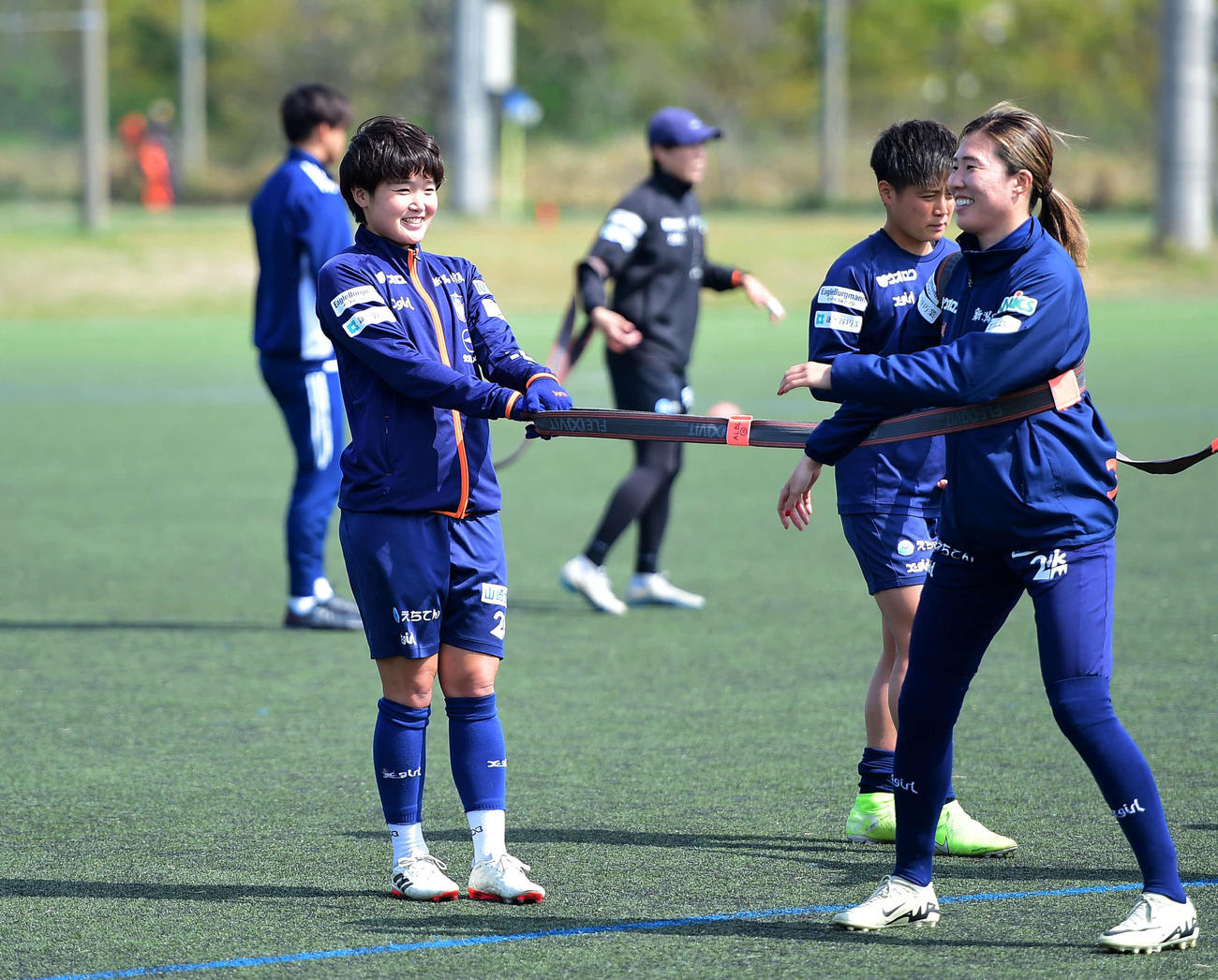 笑顔でチューブトレーニングをする新潟レディース三浦（左）
