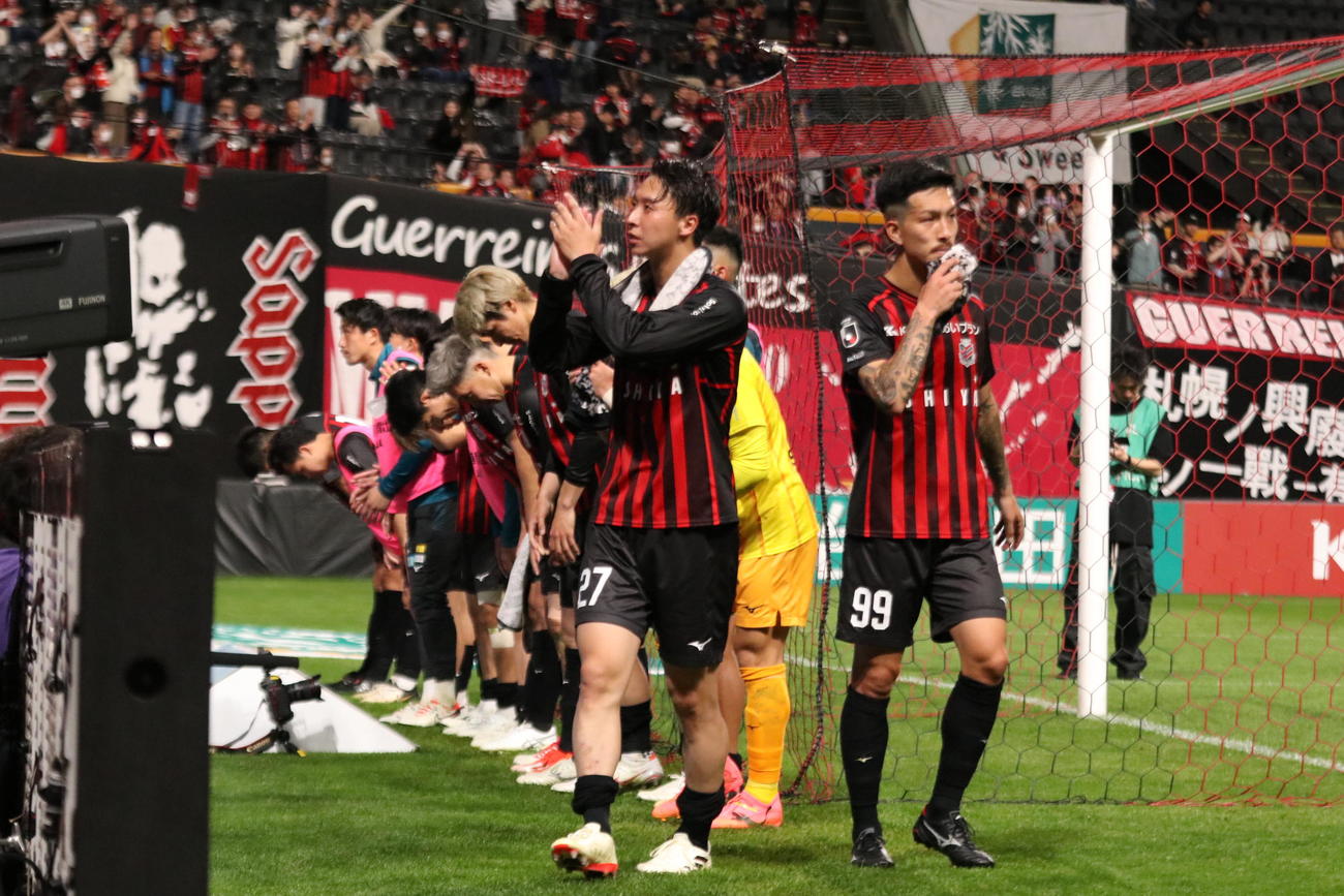 試合後スタンドに向かってあいさつする札幌の選手ら。手前は主将の荒野（撮影・保坂果那）