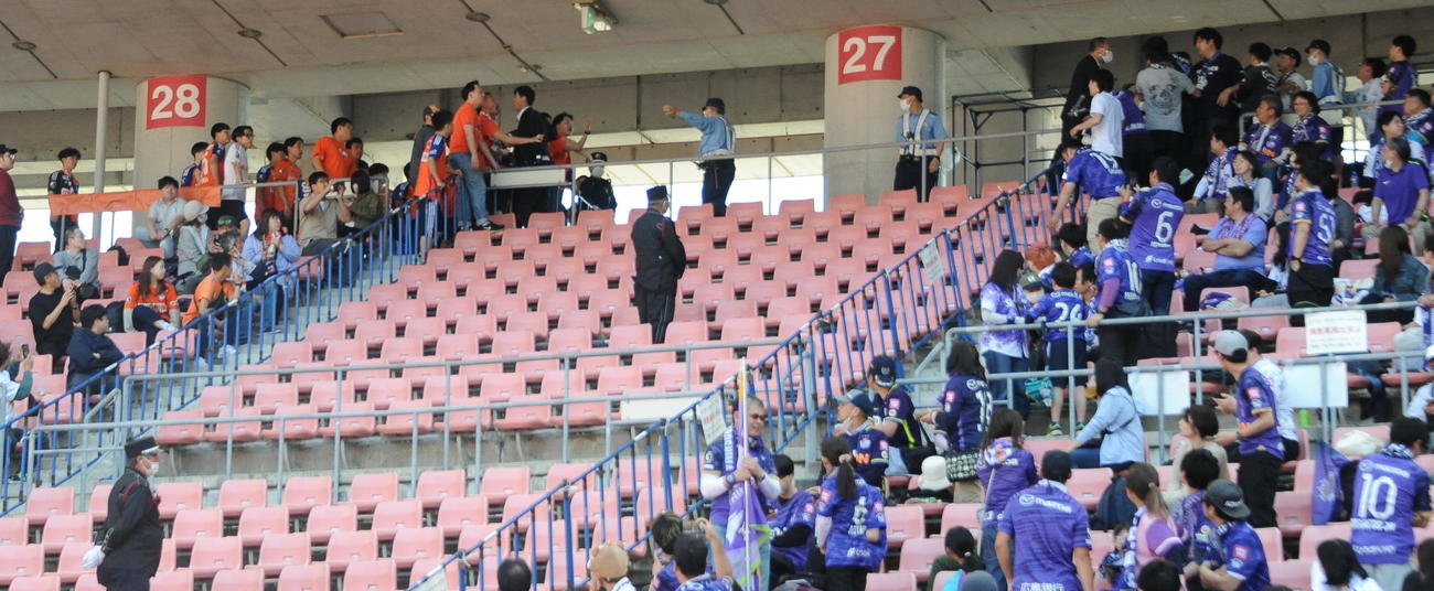 新潟の一部のサポーター（左）が広島のサポーター席に詰め寄る