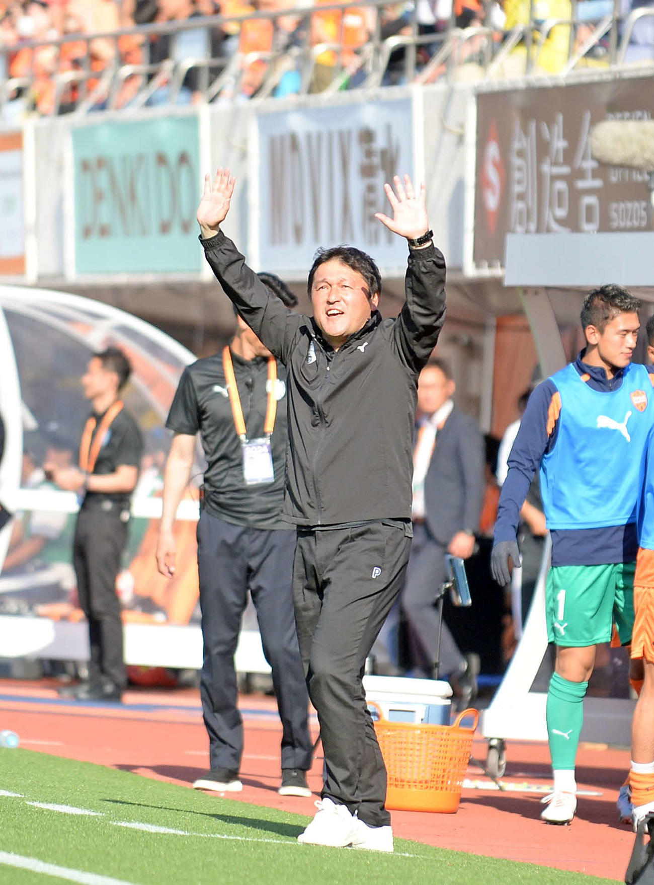 スタンドからの声援に手を振って応える清水の秋葉監督