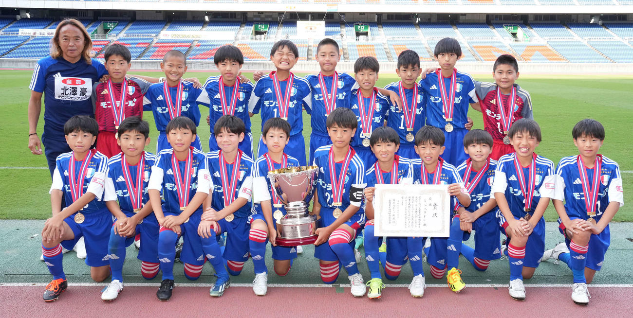 優勝したレジスタFCイレブンは北沢豪さん（左上）と記念撮影（撮影・鈴木みどり）