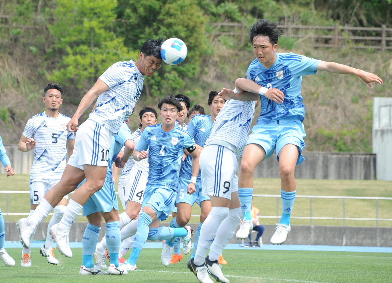 新潟医療福祉大戦で、相手のロングスローをヘディングでクリアするJAPANサッカーカレッジ・渡辺（左）