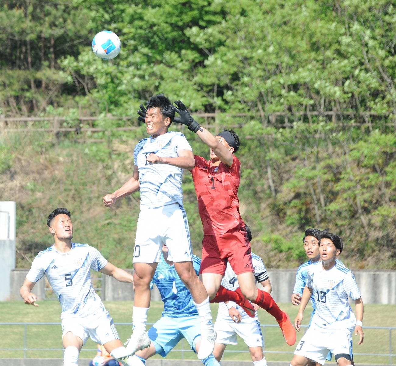 相手のロングスローをヘディングで跳ね返すJAPANサッカーカレッジ・渡辺（左から2人目）